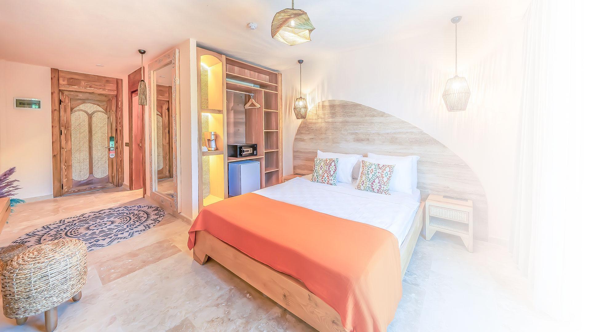 These deluxe rooms with partial sea views offer a spacious accommodation option, featuring a large bed, work desk, armchair, and a balcony to enjoy the fresh breeze.